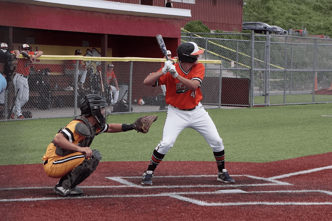 a baseball player preparing to swing at a pitch.  The catcher is behind him and ready to catch the pitch